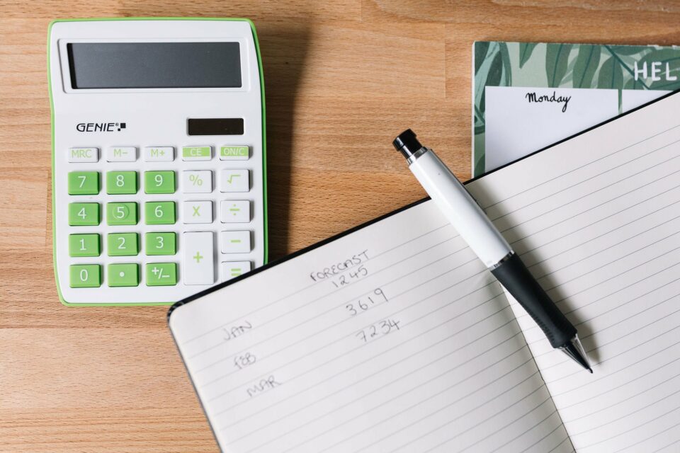 Making a sales strategy - the image shows a notebook with sales figures in it along with a pen and a calculator
